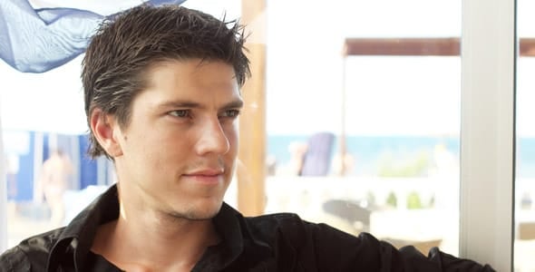 A photo of an attractive man looking off to the side and not smiling