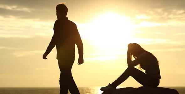 Photo of a man walking away from a woman
