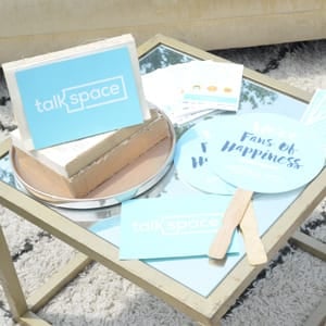 Photo of Talkspace pamphlets and fans at a festival event