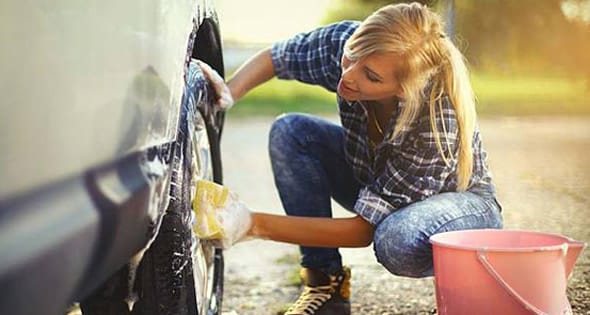 A photo of a woman taking care of her car