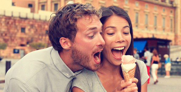 Photo of a man trying to eat a woman's ice cream cone