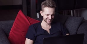 Photo of a guy smiling at a laptop