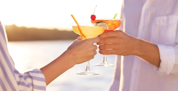 Photo of a couple holding cocktails Photo of a couple holding cocktails