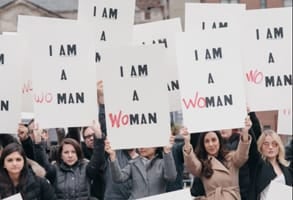 Photo of women carrying Interbrand's I AM A WOMAN signs in 2017