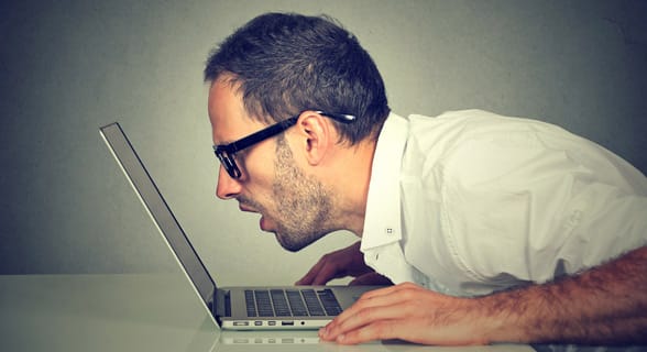 Photo of a man staring at a laptop Photo of a man staring at a laptop