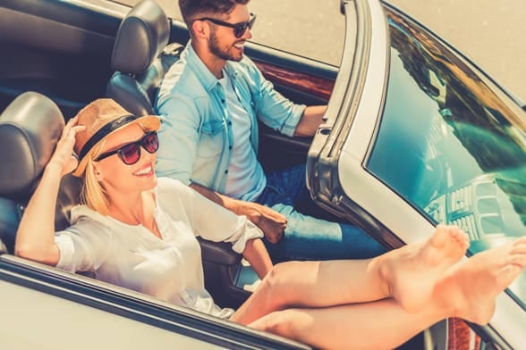 Photo of a couple smiling in a convertable