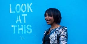 Photo of a woman in front of a blue wall