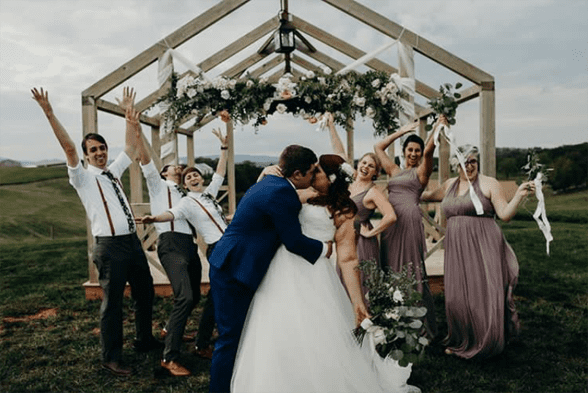 Photo of a wedding party surrounded by floral decor