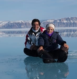 Photo of a couple sitting on the ice during an Arctic Kingdom expedition