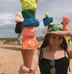 Photo of Sophwoch holding an ice cream cone under Seven Magic Mountains Photo of Sophwoch holding an ice cream cone under Seven Magic Mountains