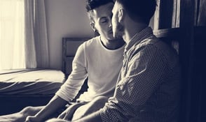 Photo of two men kissing in bed Photo of two men kissing in bed