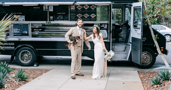Photo of a bride and groom with a food truck