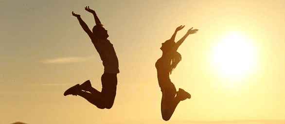 Photo of couple jumping for joy