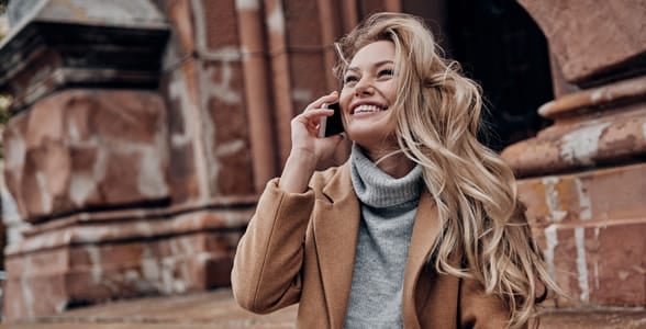Photo of a woman smiling on the phone Photo of a woman smiling on the phone