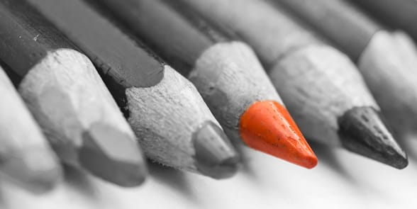 Photo of a red pencil in a group of black pencils Photo of a red pencil in a group of black pencils