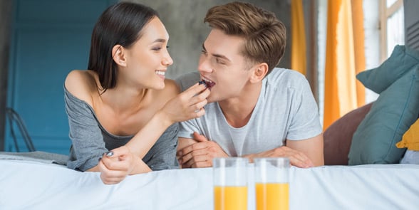 Photo of a couple having breakfast in bed