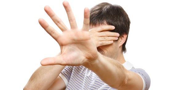 Photo of a man with his hand in front of his face
