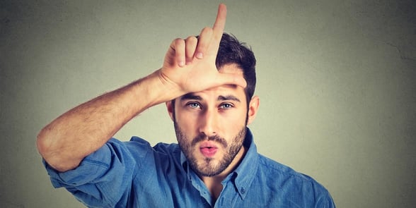 Photo of a man making an L on his forehead