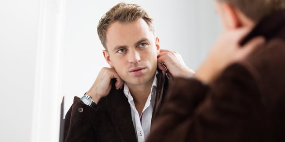 Photo of a man looking at himself in a mirror