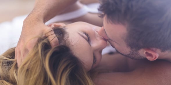 Photo of a couple kissing in bed