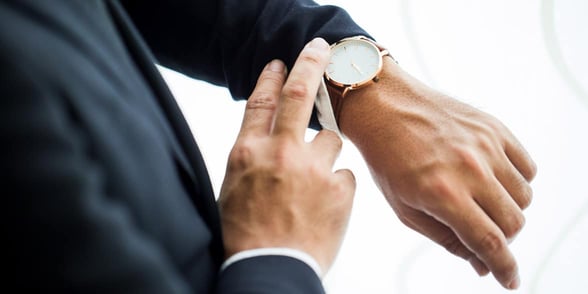 Photo of a man looking at his watch