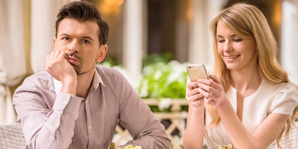 Photo of a woman on her phone during a date