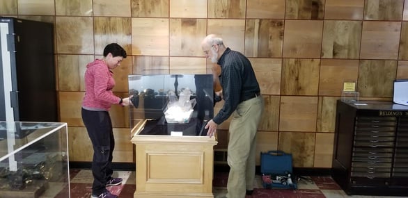 Photo of two staff members installing an exhibit at the Rice Museum