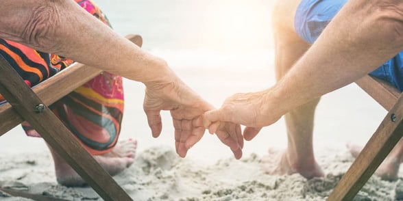 Photo of a couple holding hands at the beach