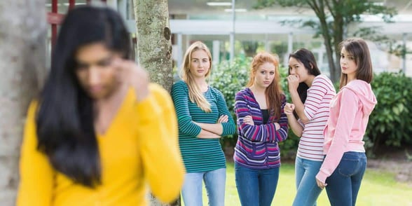 Photo of a group of women talking about another woman