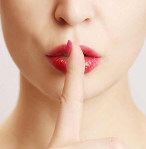 Photo of a woman holding a finger to her lips