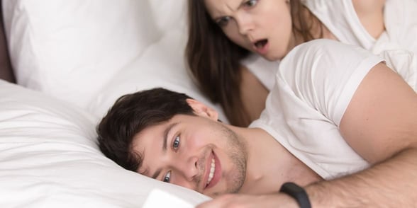Photo of a woman looking over her boyfriend's shoulder