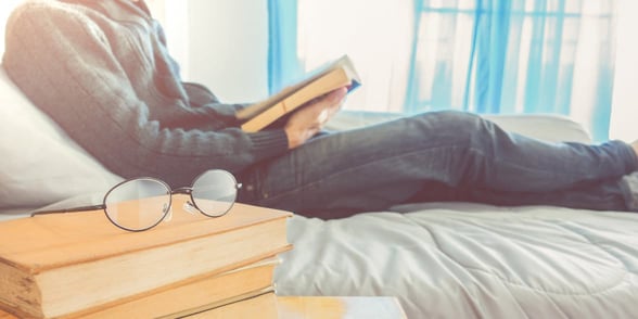 Photo of a man reading in bed