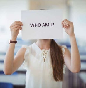Photo of a woman holding a paper over her face