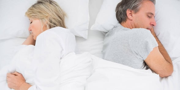 Photo of a sad couple in bed