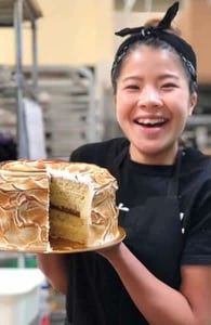Photo of a Purebread baker with a cake
