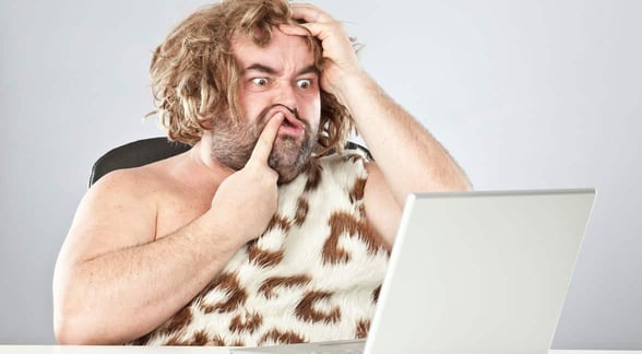 Photo of a caveman on a laptop
