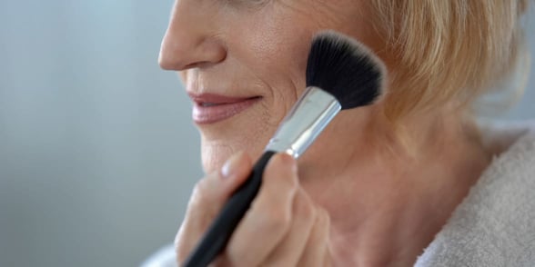 Photo of a woman putting on makeup