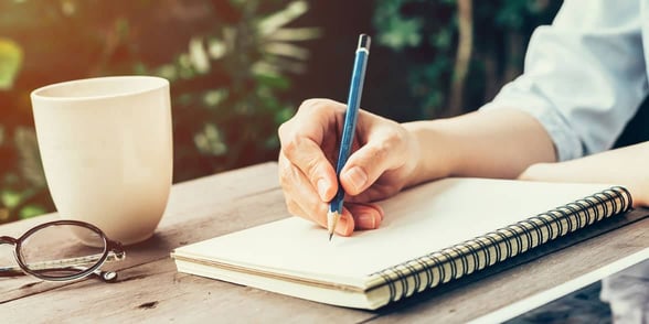 Photo of a man writing in a notebook