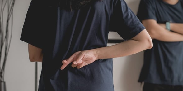 Photo of fingers crossed behind back