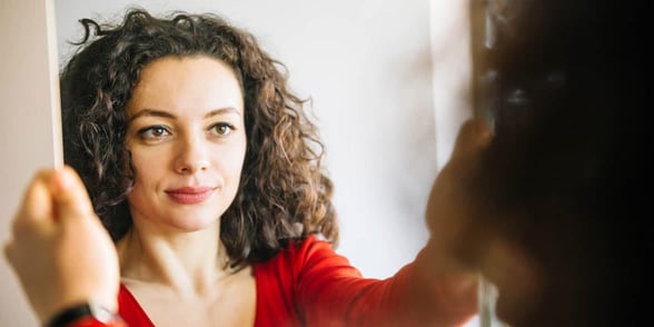 Photo of woman looking in mirror