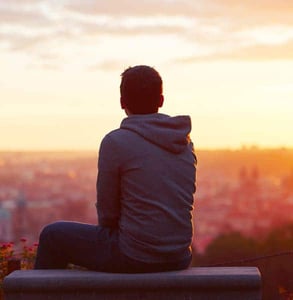 Photo of a man sitting by himself Photo of a man sitting by himself