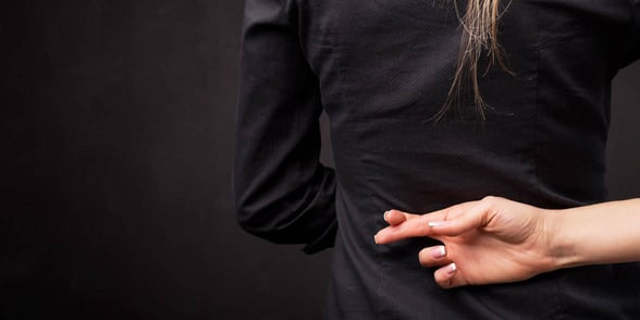 Photo of woman with fingers crossed behind back