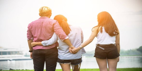 Photo of one man holding the hands of two women Photo of one man holding the hands of two women