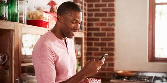 Photo of a man texting on his phone
