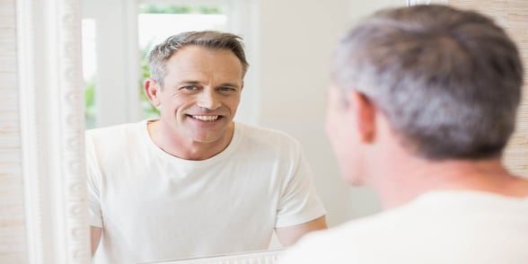 Photo of man looking in mirror