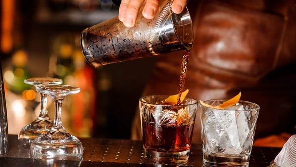Photo of a hand pouring a cocktail