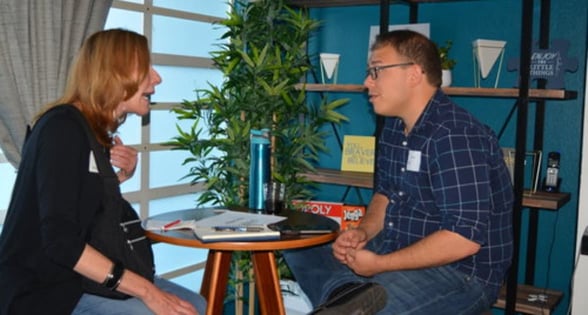 Photo of Adam Kol talking to client