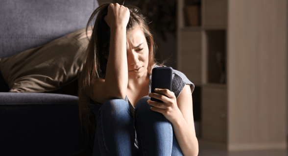 woman crying and looking at phone