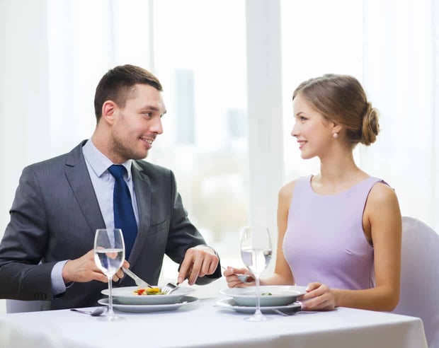 restaurant, couple and holiday concept - smiling couple eating appetizers at restaurant