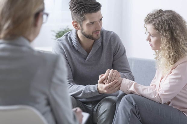 Husband apologizing to his wife during couple therapy Husband apologizing to his wife during couple therapy